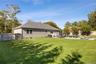Rear view of property featuring a fenced backyard, a patio area, and a shingled roof