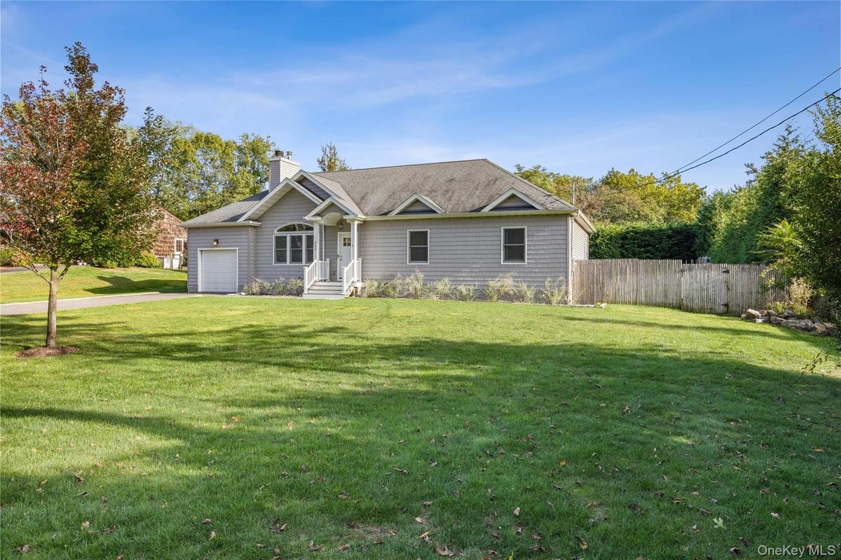 Ranch-style house with a chimney, a garage, and driveway