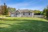 Ranch-style house with a chimney, a garage, and driveway