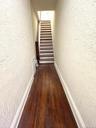Hall with a textured wall, dark wood finished floors, and stairway
