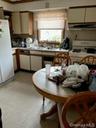 Kitchen featuring light countertops, white appliances, and range hood