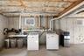 Washroom with separate washer and dryer and concrete floors
