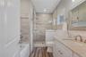 Bathroom featuring a shower stall, vanity, a bath, dark wood-type flooring, and recessed lighting