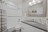 Bathroom with shower / tub combo, vanity, and wainscoting
