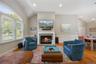 Living area featuring lofted ceiling, a fireplace with flush hearth, wood finished floors, a chandelier, and recessed lighting