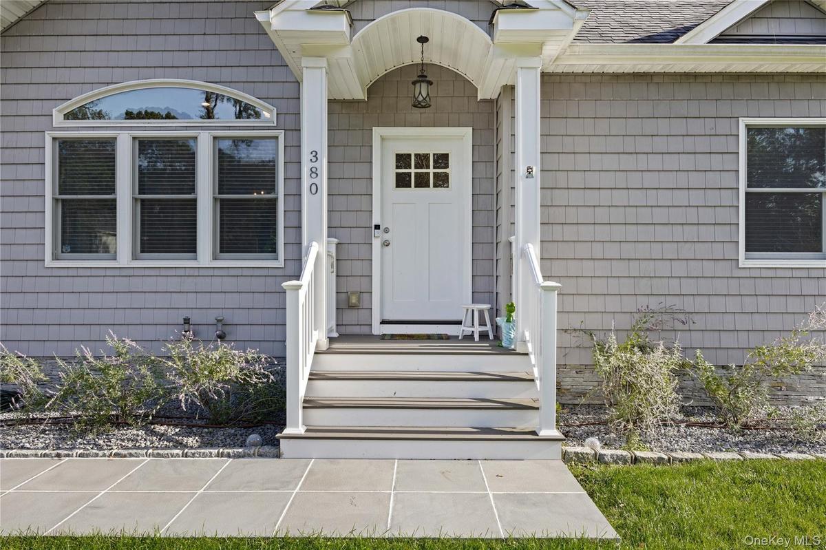 View of exterior entry with a shingled roof