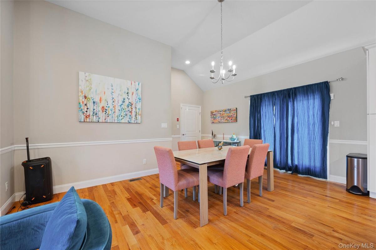 Dining area with light wood-style flooring, a chandelier, recessed lighting, and high vaulted ceiling