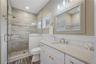 Bathroom featuring vanity, a stall shower, dark wood finished floors, and recessed lighting