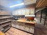 Bar featuring wooden walls, light wood-style flooring, stainless steel gas cooktop, and range hood