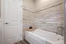 Bathroom featuring a garden tub and dark wood finished floors