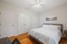 Bedroom with light wood-style flooring, a ceiling fan, and two closets