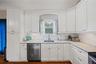 Kitchen with white cabinets, light stone countertops, and stainless steel appliances