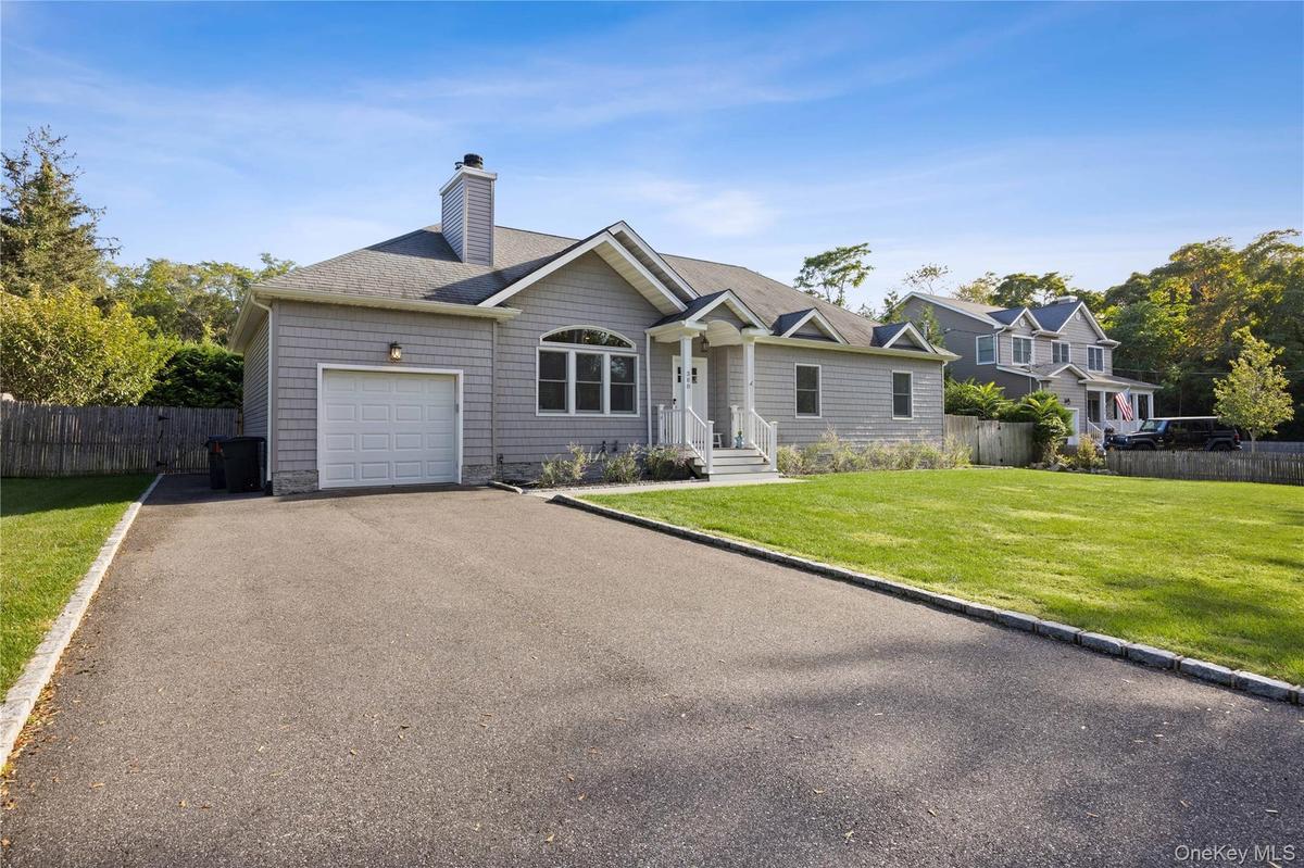 Single story home with asphalt driveway, a shingled roof, a chimney, and an attached garage