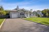 Single story home with asphalt driveway, a shingled roof, a chimney, and an attached garage