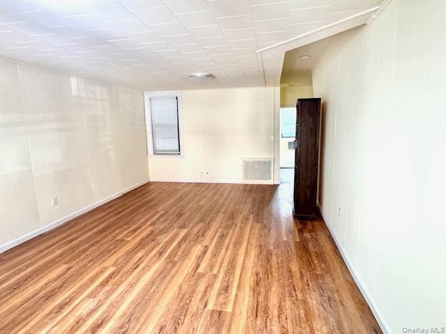 Empty room with light wood-style flooring and healthy amount of natural light