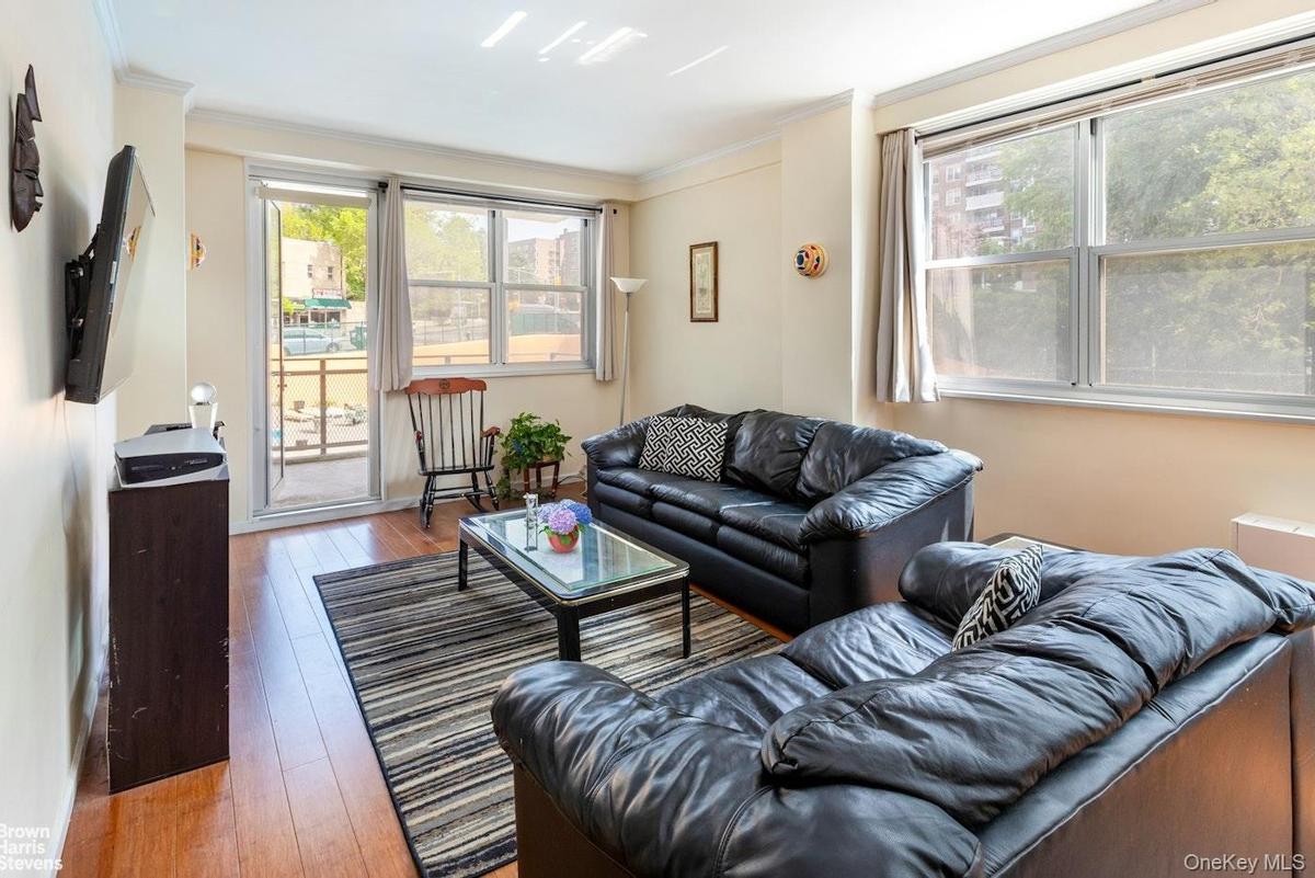 Living room with hardwood / wood-style floors and crown molding