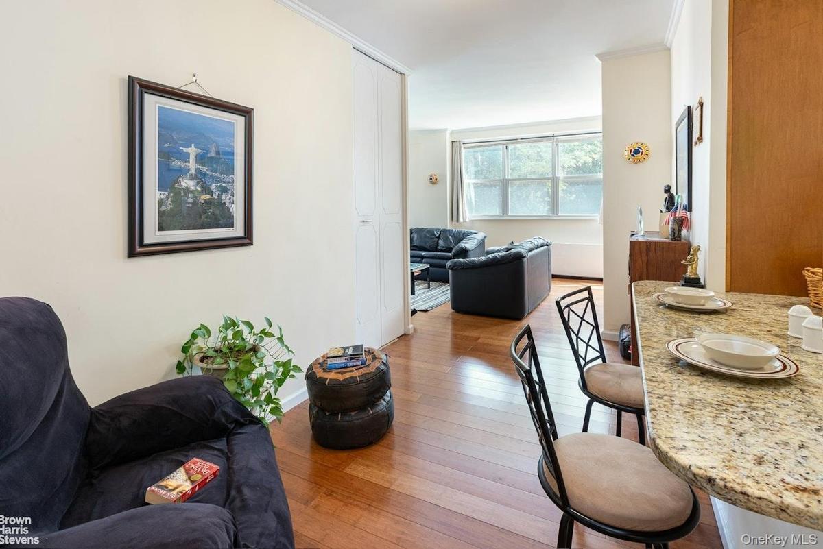 Dining area featuring hardwood / wood-style floors, crown molding, and baseboards