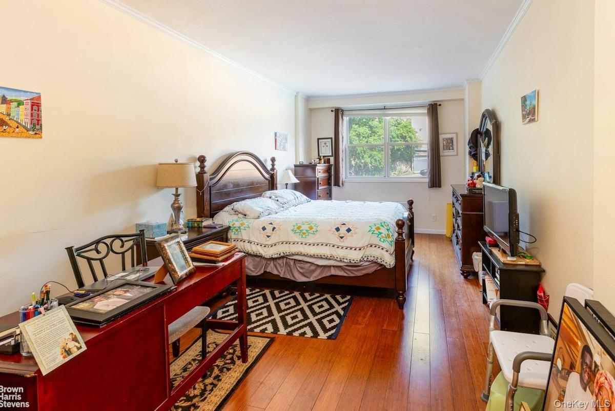 Bedroom featuring ornamental molding and hardwood / wood-style floors