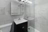 Bathroom with vanity, a shower stall, toilet, and tile walls