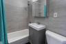Bathroom with shower / tub combo, vanity, toilet, and tile walls