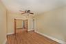 Unfurnished room featuring light wood-type flooring, a ceiling fan, and french doors