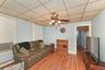 1st Floor Living area with ceiling fan, baseboard heating, wood finished floors, cooling unit, and a paneled ceiling