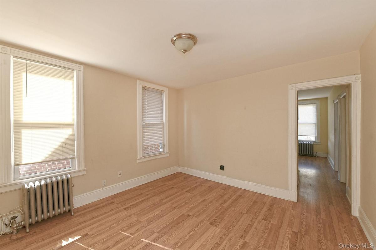 Spare room featuring radiator heating unit and light wood-style flooring