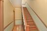 Stairway with crown molding and wood finished floors