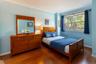 Bedroom featuring wood finished floors, baseboards, and ornamental molding