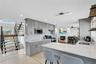 Kitchen with gray cabinets, light stone countertops, light wood-style flooring, and recessed lighting