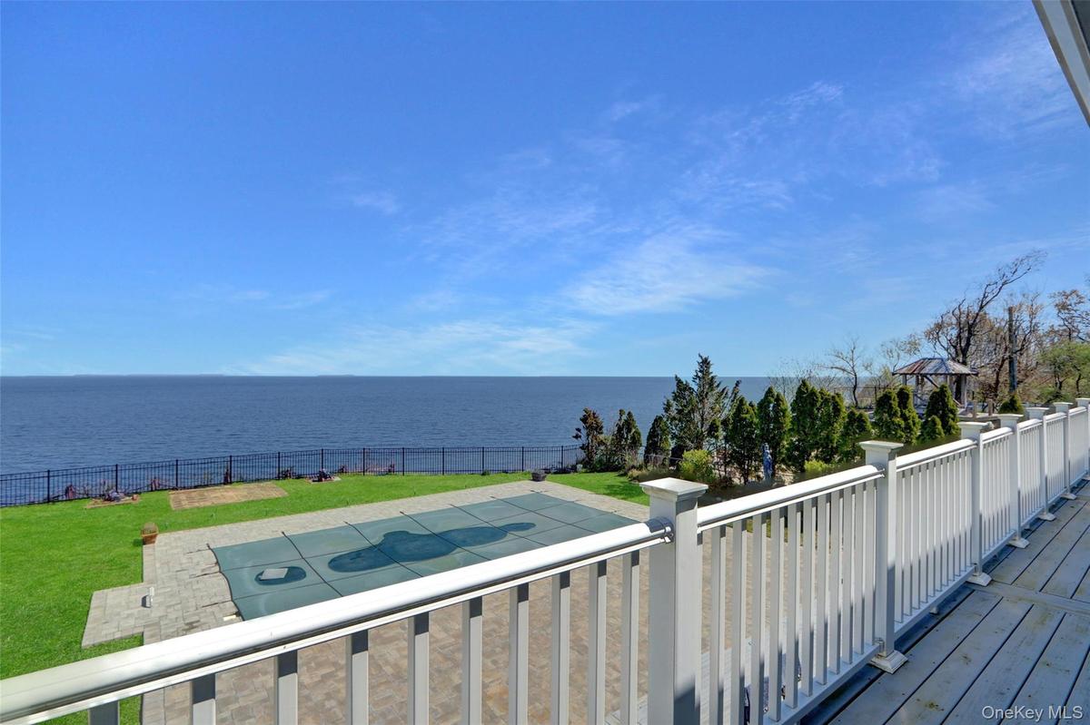 Wooden deck featuring a water view and a fenced backyard