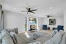 Living area with light wood-style floors, a wood stove, recessed lighting, and a ceiling fan