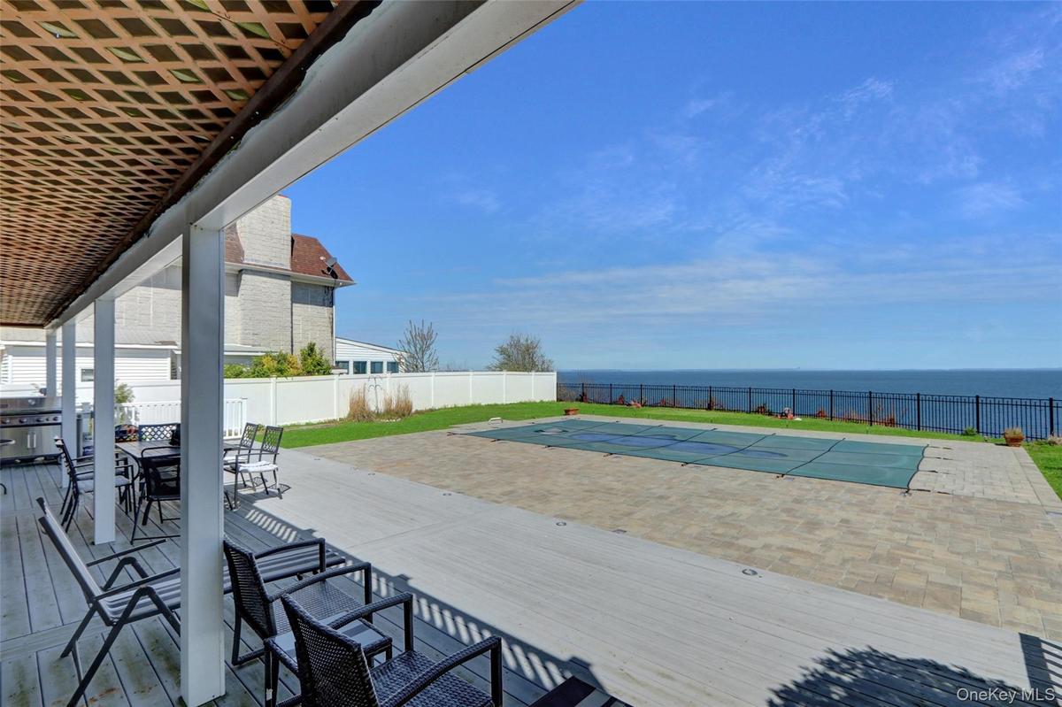 Deck with a patio area, a fenced backyard, a water view, and outdoor dining area