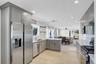 Kitchen featuring decorative backsplash, stainless steel appliances, gray cabinetry, recessed lighting, and open shelves