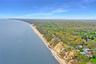 Drone / aerial view of unending shoreline and a heavily wooded area