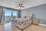 Bedroom with access to outside, a water view, light wood finished floors, and ceiling fan