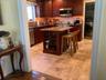 Kitchen with decorative backsplash, dark stone countertops, a kitchen bar, and glass insert cabinets