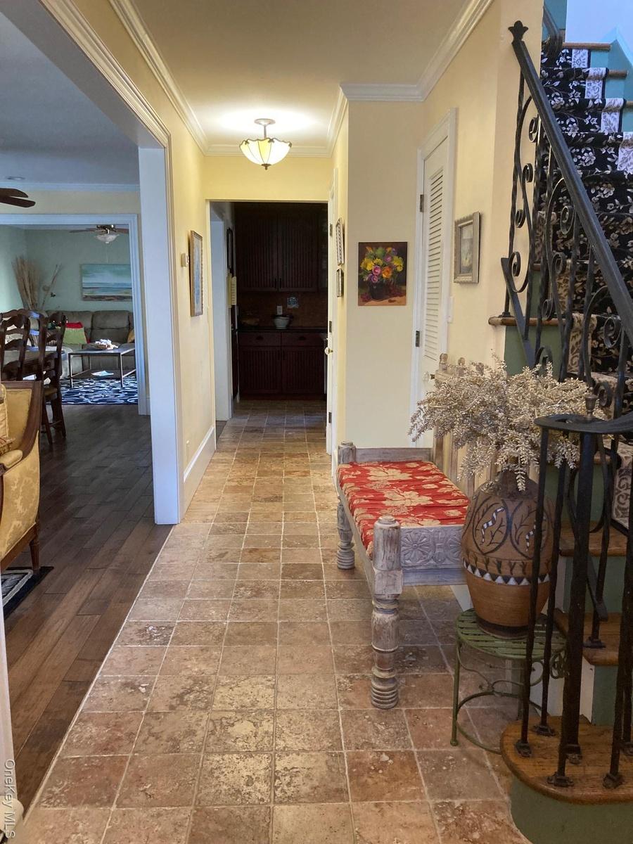 Corridor featuring crown molding and baseboards