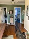 Corridor with dark wood finished floors, crown molding, attic access, and an upstairs landing