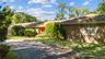 Single story home with brick, driveway, and a front yard