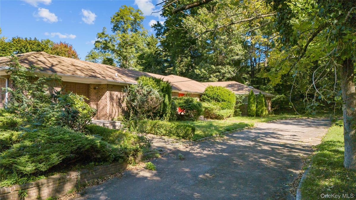 View of front of home with driveway and brick.