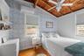Bedroom with light wood-type flooring, wallpapered walls, wooden ceiling, a wall unit AC, and ceiling fan