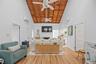 Living room featuring high vaulted ceiling, a fireplace, wood finished floors, and wood ceiling