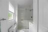 Bathroom with a stall shower, vanity, and lofted ceiling