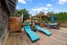 Wooden terrace featuring a hot tub, outdoor dining area, and a fenced backyard