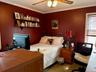 Bedroom featuring ornamental molding, a desk, a ceiling fan, and carpet floors
