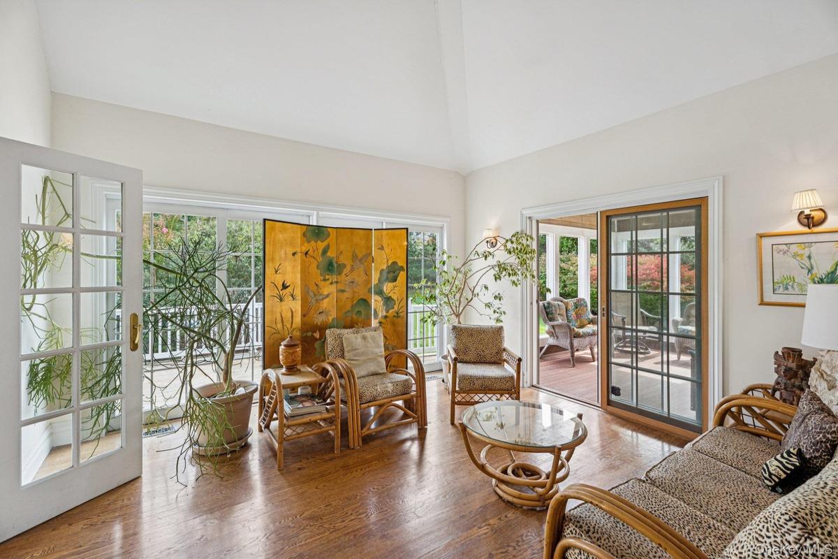 An inviting living area adorned with rich wood-finished floors and a breathtaking cathedral ceiling that enhances the home’s airy elegance.