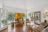 An inviting living area adorned with rich wood-finished floors and a breathtaking cathedral ceiling that enhances the home’s airy elegance.