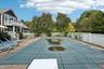 A picturesque view showcasing the swimming pool, sunlit patio, and hot tub, all set within a private fenced backyard and complemented by a balcony ove