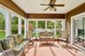 Sunroom featuring a ceiling fan, mahogany wood walls, and a warm, inviting ambiance.